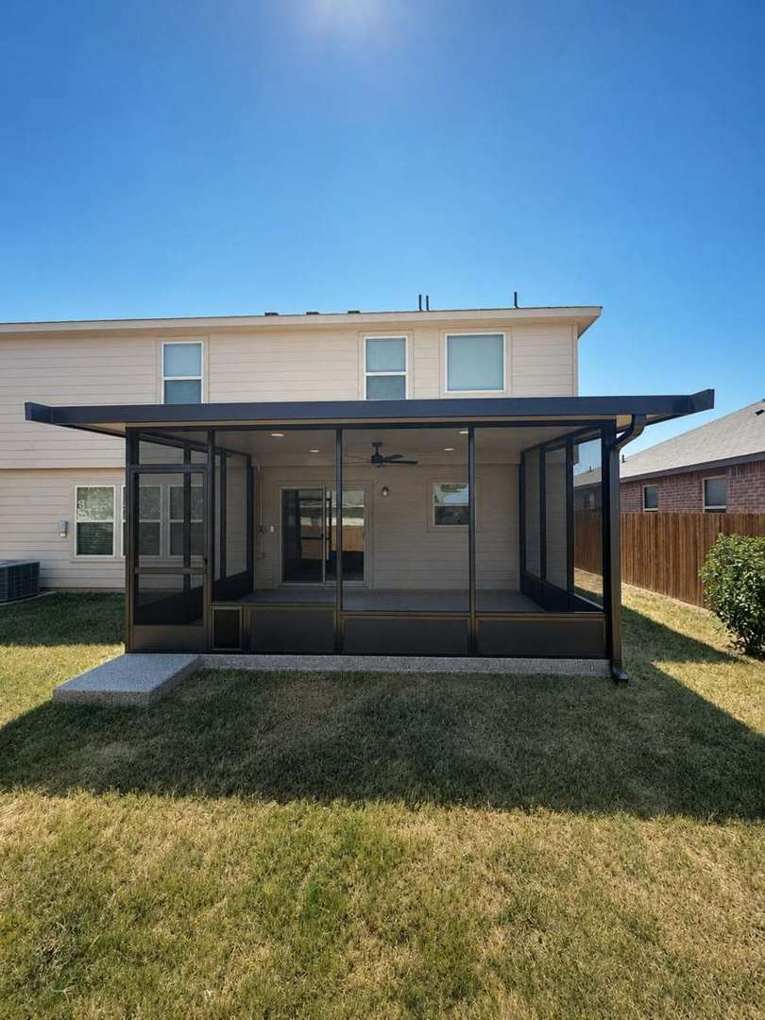 Screen room centered across the full back of the home under its cantilevered roof