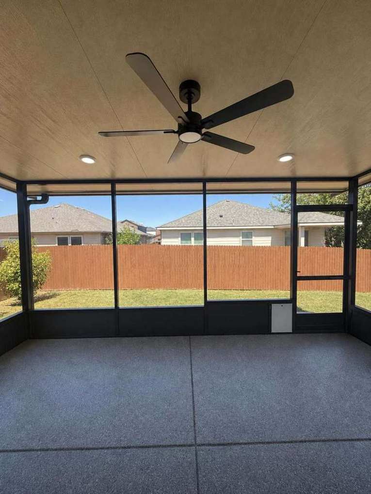 Inside the Almanza screen room — ceiling fan, full-height screens, flake-coated floor