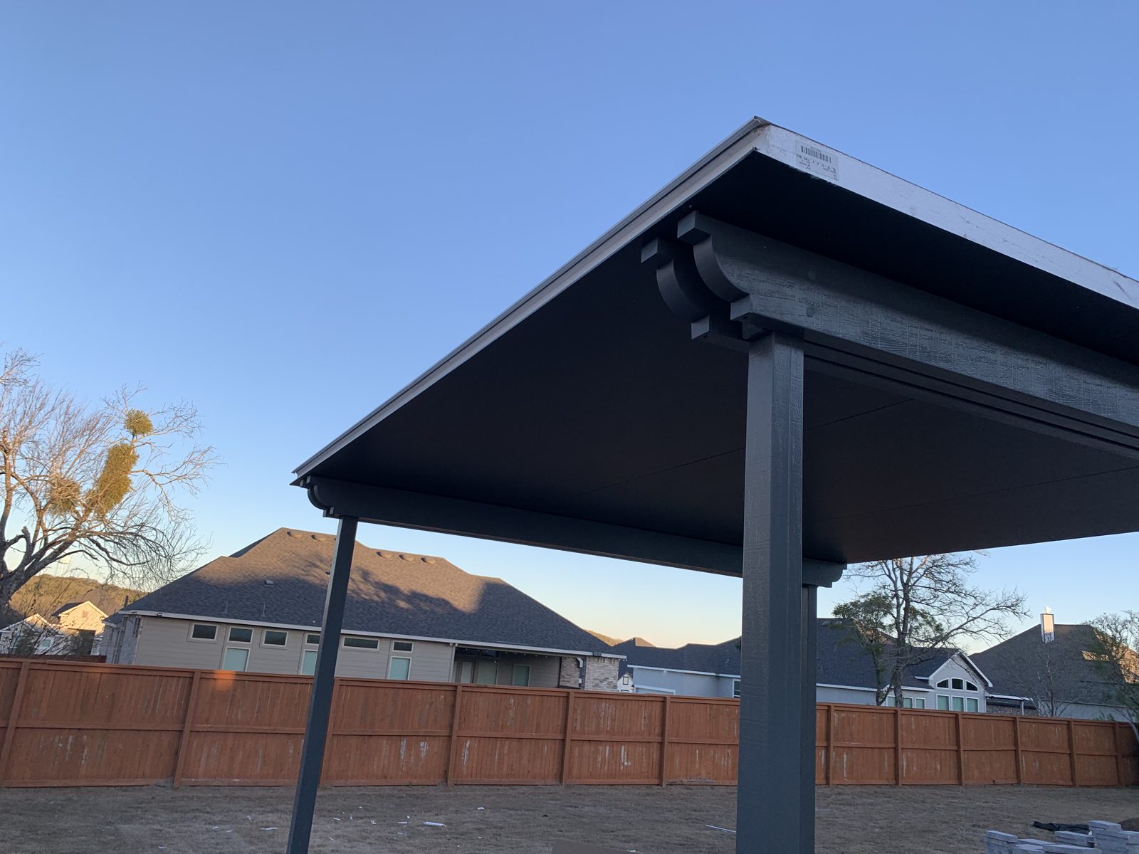 Freestanding cover with corbel rafter tails at dusk