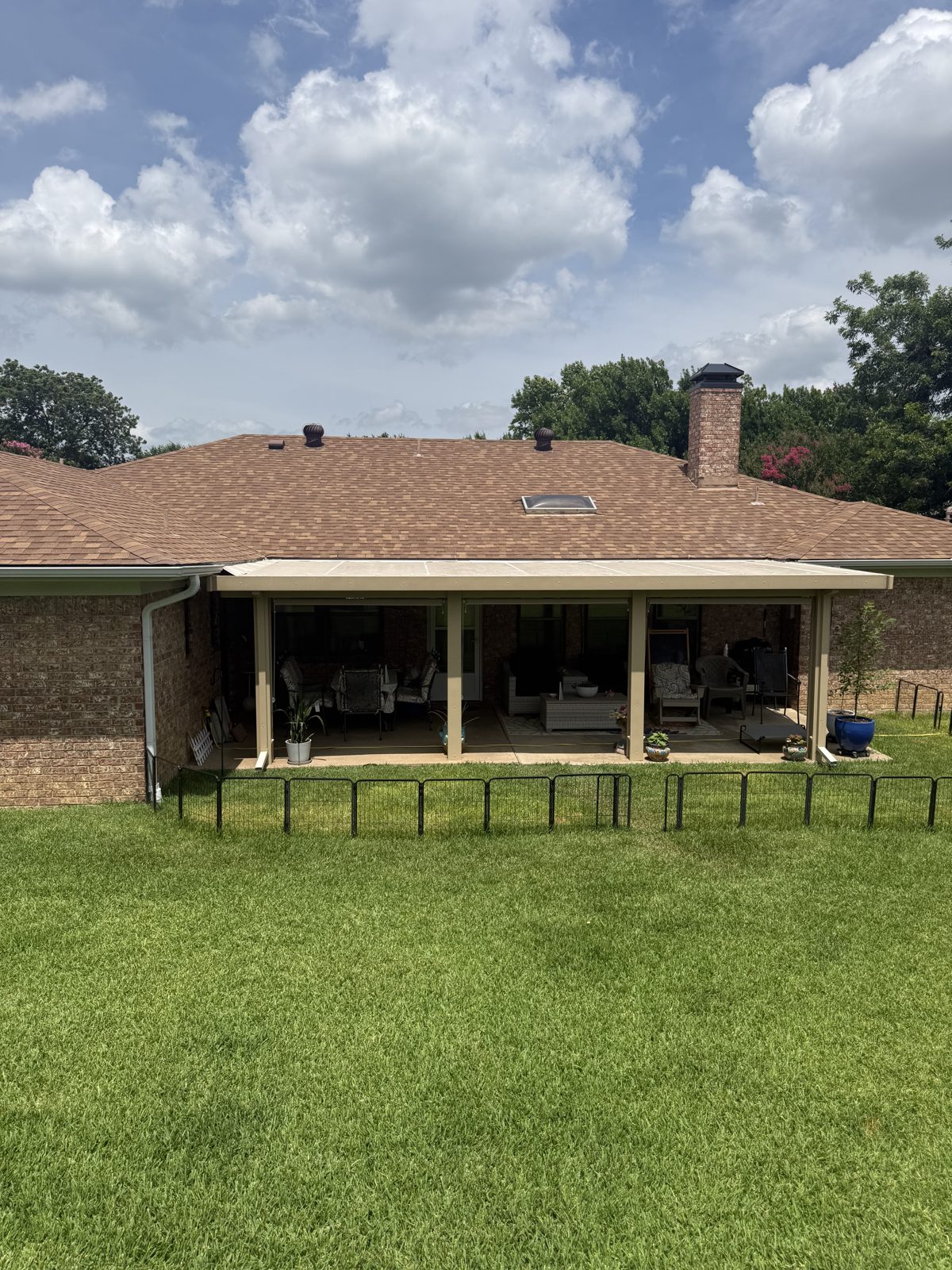 Full-width patio cover on brick home