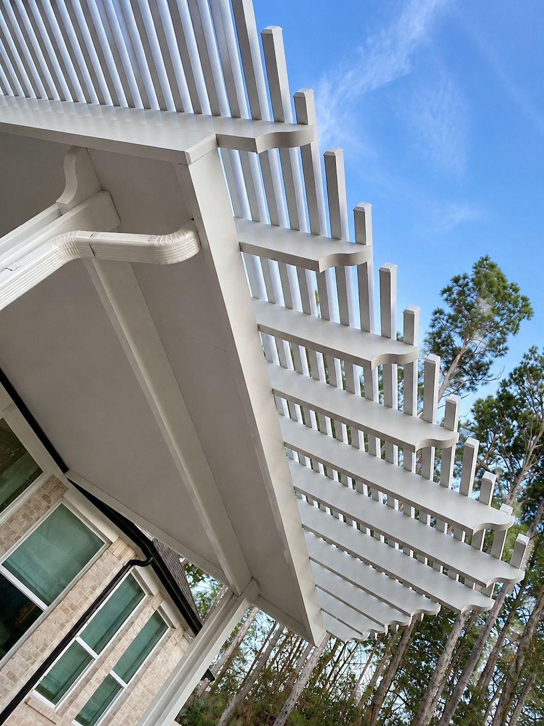 Underside detail of the hybrid cover where the solid roof meets the scalloped lattice rafters