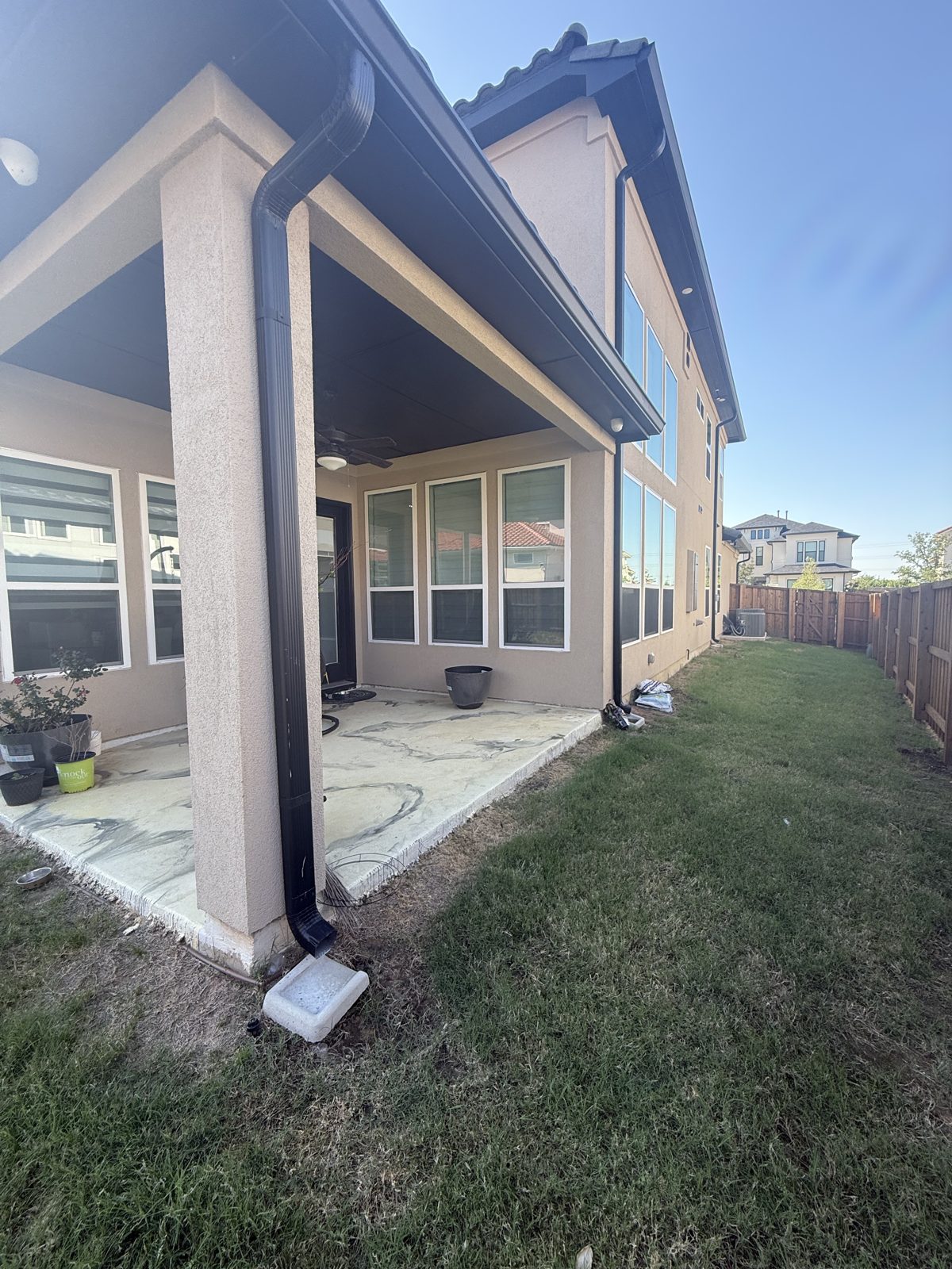 Stucco patio cover with black tongue-and-groove ceiling