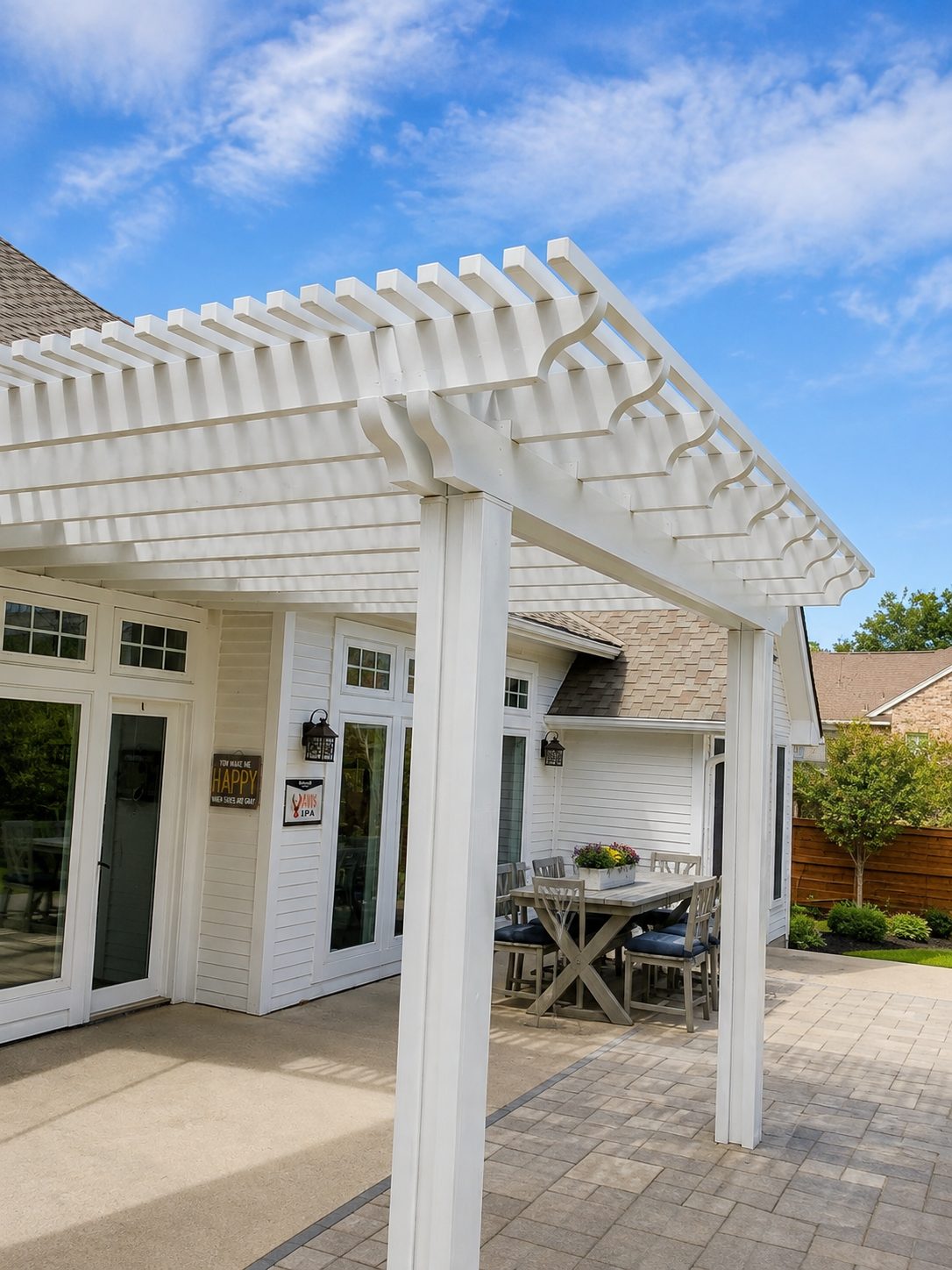 White lattice pergola shading a brick home patio