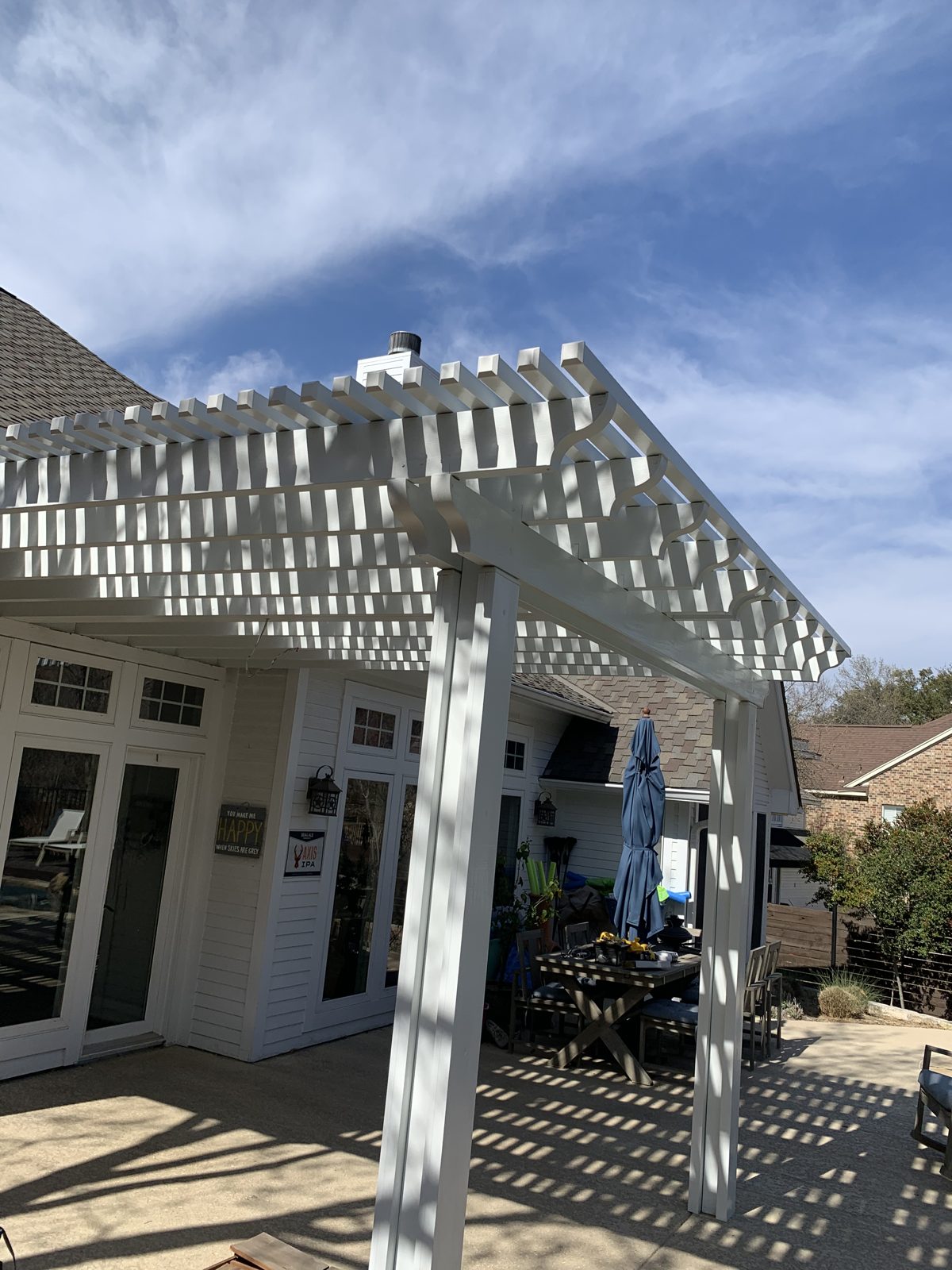 White lattice pergola on brick home