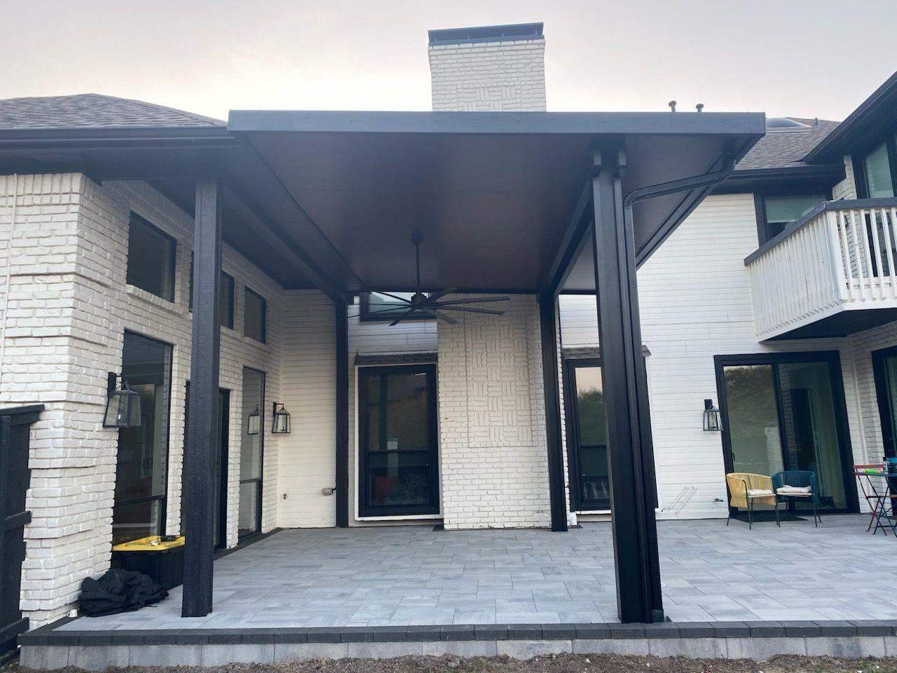 Black flat-roof cover on white modern home